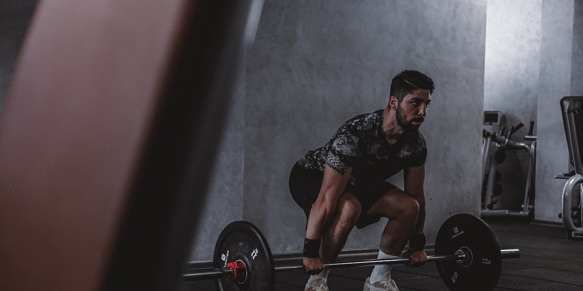 Man lifting weights in gym, displaying strength and focus. Ideal for fitness and training themes.